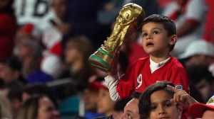 Young Peru fan holds a replica of the FIFA World Cup trophy